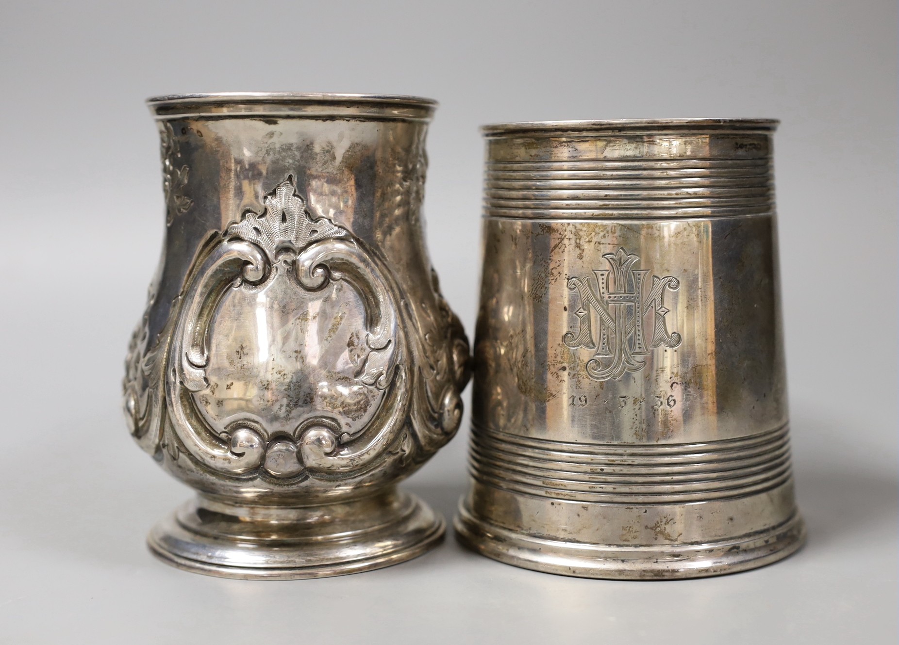 A George V silver mug, with reeded bands, Elkington & Co, Birmingham, 1935, 11.5cm and a Victorian repousse silver baluster mug, Robert Harper, London, 1862, 23.8oz.